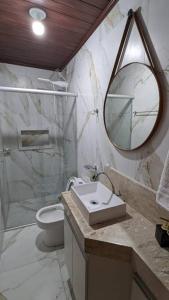 a bathroom with a sink and a toilet and a mirror at Casa histórica do escravo isidoro in Diamantina +13 photos