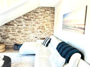 sala de estar con sofá blanco y pared de ladrillo en Latakia - Heritage Tay Basin Waterfront Maisonette, en Perth