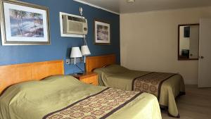 two beds in a hotel room with blue walls at FOUR OAKS in Conway
