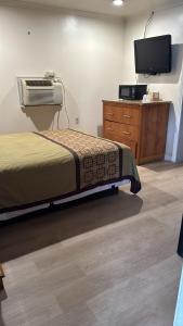 um quarto com uma cama e uma televisão numa cómoda em FOUR OAKS em Conway