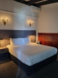 a bedroom with a large bed with a wooden headboard at Lakeview Colonial House in Queenstown
