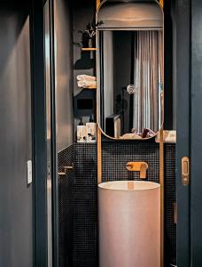 baño con lavabo redondo y espejo en The Green Rooms - Luxury themed micro apartments inspired by tiny home design en Canberra
