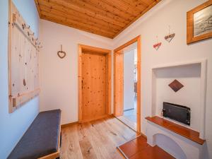 a room with a wooden door and a tv on a wall at Strasshof in Stuhlfelden