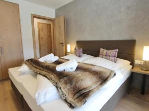 a bedroom with a large bed with a blanket on it at Kitzbüheler Alpenlodge Top A3 in Mittersill