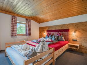 two beds in a room with wooden walls at Strasshof in Stuhlfelden