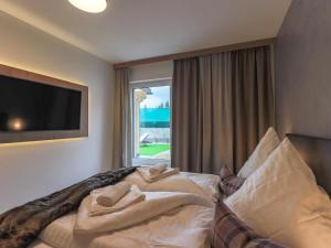 a hotel room with a bed with pillows and a window at Kitzbüheler Alpenlodge Top A3 in Mittersill