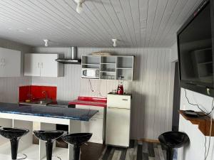 a kitchen with red and white cabinets and black stools at Arenas de Ancud in Ancud +9 photos