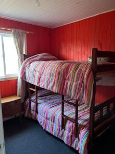 a bedroom with two bunk beds in a red wall at Arenas de Ancud in Ancud