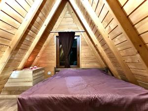 uma cama grande num quarto de madeira com uma janela em Villa Panorama em Lipljan