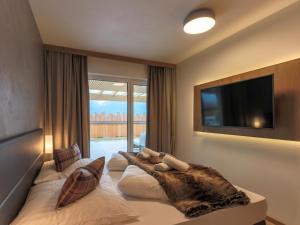 a bedroom with a large bed with a tv on the wall at Kitzbüheler Alpenlodge Top A2 in Mittersill
