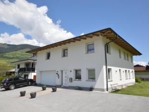 a white house with a car parked in a driveway at Karo in Mittersill