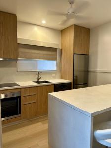 a kitchen with wooden cabinets and a counter top at Lake Tinaroo Holiday Park in Tinaroo