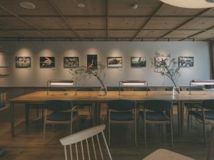 uma mesa num quarto com cadeiras e quadros na parede em Chalet Shiga em Yamanouchi