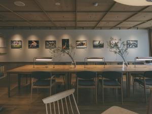 a table in a room with chairs and pictures on the wall at Chalet Shiga in Yamanouchi