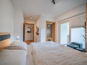 a bedroom with a large bed and a window at Kitzbüheler Alpenlodge Top A8 in Mittersill