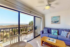 a living room with a blue couch and a balcony at Casa Al Mare in Carolina Beach