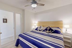 a bedroom with a bed with blue and white stripes at Casa Al Mare in Carolina Beach
