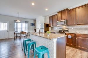 a kitchen with wooden cabinets and blue stools at Union City Townhome 17 Mi to Downtown Atlanta! in Union City