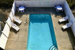 an overhead view of a swimming pool with chairs and tables at Three Sea in Carolina Beach