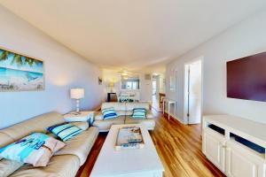 a living room with a couch and a flat screen tv at Three Sea in Carolina Beach
