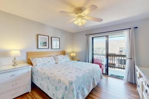 a bedroom with a bed and a ceiling fan at Three Sea in Carolina Beach +42 photos