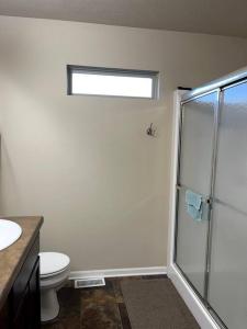 a bathroom with a toilet and a glass shower at Cheerful 3 bd home with easy access to interstate! in Omaha