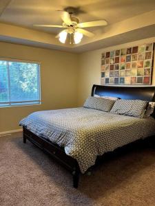 a bedroom with a bed with a ceiling fan at Cheerful 3 bd home with easy access to interstate! in Omaha