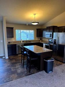 a kitchen with a table and chairs and a refrigerator at Cheerful 3 bd home with easy access to interstate! in Omaha