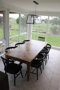 a dining room with a wooden table and chairs at Gladbyrne in Braidwood