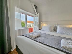 a bedroom with a large white bed with a window at LM art apartments in Porto +54 photos