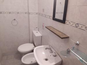 a white bathroom with a toilet and a sink at Hotel Manzanares Plaza in Buenos Aires +11 photos