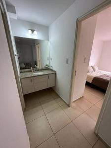 uma casa de banho com um lavatório, um espelho e uma cama em Apartment in Nueva Cba, amazing location, terrace em Córdoba