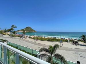 uma varanda com vista para a praia e para o oceano em Frente mar- Apto pé na areia com charme e conforto no Rio de Janeiro