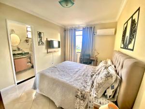 a bedroom with a bed and a bathroom with a sink at Top Ap 3 Qts a 3 quadras da orla Sua família sem aperto Não sofra férias, desfrute-as in Aracaju