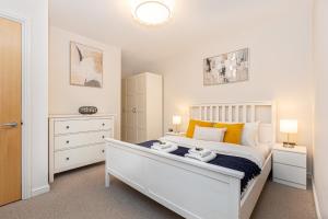sypialnia z białym łóżkiem i 2 ręcznikami w obiekcie Hidden Gem 2BR flat wBalcony near Surrey Quays w Londynie