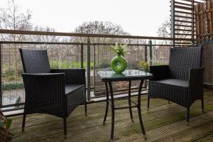 een balkon met stoelen en een tafel met een vaas erop bij Hidden Gem 2BR flat wBalcony near Surrey Quays in Londen