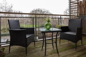 a balcony with chairs and a table with a vase on it at Hidden Gem 2BR flat wBalcony near Surrey Quays in London