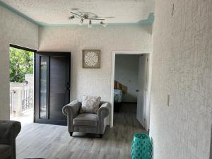 a living room with a chair and a bedroom at Departamento cómodo y céntrico en Malinalco. in Malinalco