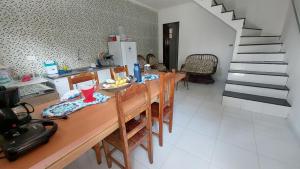 a kitchen with a wooden table with chairs and a dining room at Residencial Maria de Lourdes in Ibicoara
