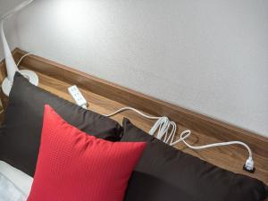 une tête de lit avec des oreillers rouges et noirs dans l'établissement Murata COPO 305 / Vacation STAY 2893, à Tokyo
