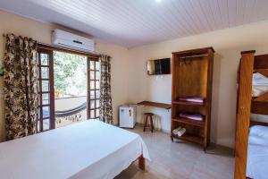 a bedroom with a bed and a large window at pousada formibela in Ilhabela