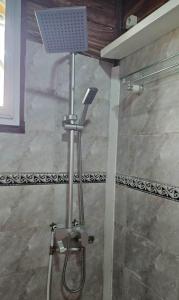 y baño con ducha con cabezal de ducha. en Le Chalet Kapélet en Kribi