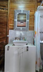 a bathroom with a sink and a mirror at Le Chalet Kapélet in Kribi