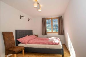 um quarto com uma cama com almofadas vermelhas e uma janela em Am Strubelweg em Adelboden