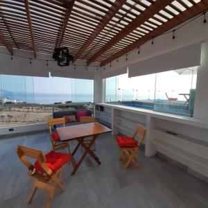 a dining room with a table and chairs and windows at CASA DE PLAYA Todo el año in Punta Negra