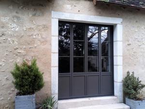 una puerta corredera de cristal en el lateral de un edificio en Gîte Communauté de communes Brenne - Val de Creuse-Ciron, 2 pièces, 4 personnes - FR-1-591-21, en Ciron