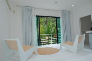 a white room with two chairs and a window at MoonE in Ban Karon