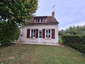 a small white house with red windows and a yard at Charmante maison dans le Parc de la Brenne, idéale pour familles avec jardin, proche zoo et activités nature - FR-1-591-83 in Pouligny-Saint-Pierre