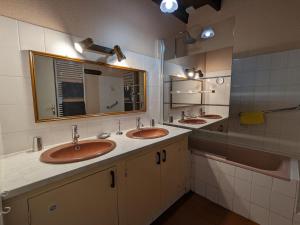a bathroom with two sinks and a mirror at Gîte familial près de Nohant avec jardin, cheminée, garage et WIFI gratuit - FR-1-591-94 in Nohant-Vic +15 photos