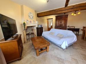 una camera da letto con un letto, una tv e un tavolo di Charmant Gîte en Brenne avec Jardin, Piscine Partagée et Proximité Sentiers de Randonnée - FR-1-591-99 a Prissac Altre 23 foto